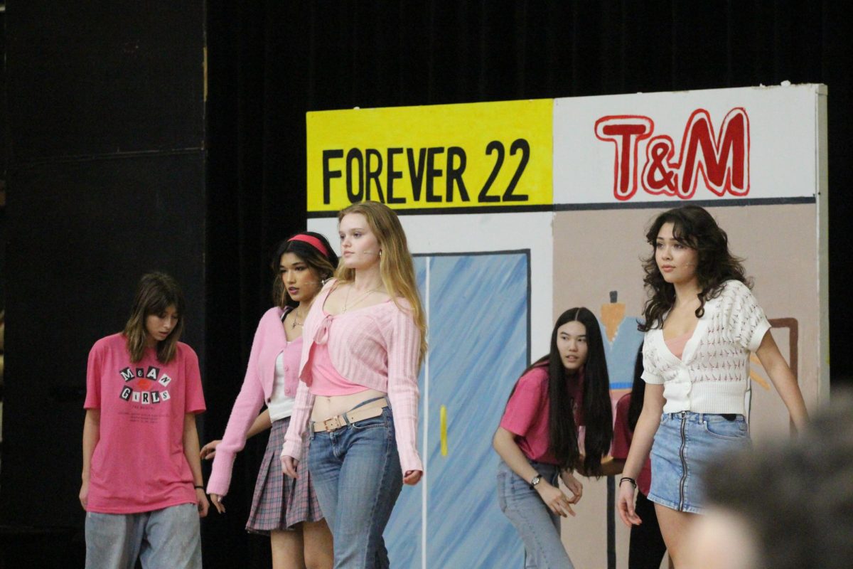 The Plastics make their iconic entrance walk to the song Meet The Plastics.