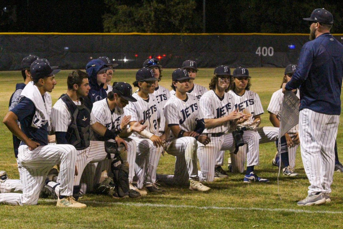 Coach Trevor Sampson shares words of praise with his team before presenting them with the championship banner. 