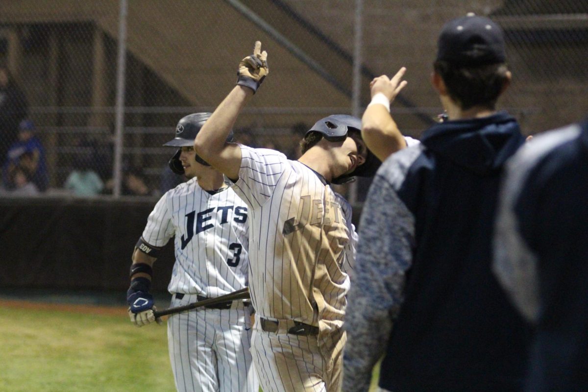 Senior Hudson Taylor celebrates with teammates after sliding into home during the 4th inning.