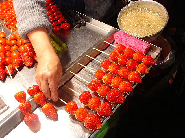 Fresh strawberry tanghulu being made to sell. 